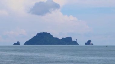 Turkuaz su plajındaki feribot manzaralı tropik cennet manzarası ve Amphoe Mueang Krabi Tayland 'daki Ao Nang Sahili' ndeki kireçtaşı tepeleri ve dağlar arasındaki uçurum..