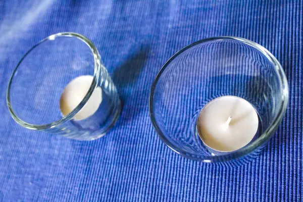 Two tealights candles in glass on blue tablecloth in Hemmoor Hechthausen Cuxhaven Lower Saxony Germany.