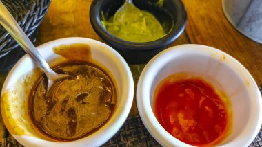 Playa del Carmen Quintana Roo Meksika 'da 3 sos yeşil kişniş kırmızısı ketçap ve barbekü.