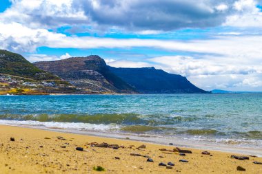 Turkuaz mavi su dağları manzaralı Long Beach manzara manzarası ve Simons Town Capetown Batı Capetown Burnu Güney Afrika Güney Afrika 'da bulutlu mavi gökyüzü.