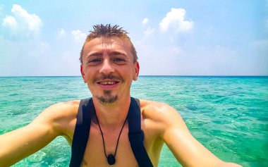 Sudaki süper mutlu adam ve Rasdhoo Mercan Maldivleri 'ndeki Rasdhoo adasındaki paradisikal tropikal bir plajda.