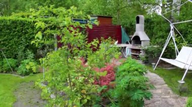 Leherheide Bremerhaven Bremen Almanya 'sında ağaçlı yeşil bahçe gübre yatakları çimenlik ve barbekü alanı.