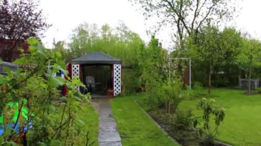 Leherheide Bremerhaven Bremen Almanya 'sında ağaçlı yeşil bahçe gübre yatakları çimenlik ve barbekü alanı.