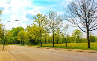 Güneşli bir günde doğal manzara yürüyüş yolu patika yolu yeşil ağaçlar Leherheide Bremerhaven Almanya ormanında.