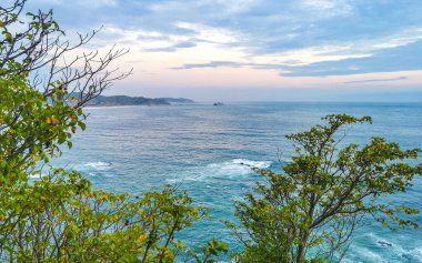 Punta ve Playa Cometa günbatımı dalgalarla uçurum uçurumları dağ tepeleri kayalar tropik doğa orman manzaralı kayalar Mazunte Oaxaca Meksika manzaralı.