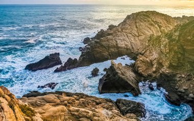 Punta ve Playa Cometa günbatımı dalgalarla uçurum uçurumları dağ tepeleri kayalar tropik doğa orman manzaralı kayalar Mazunte Oaxaca Meksika manzaralı.
