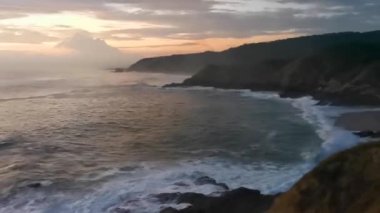 Punta ve Playa Cometa günbatımı dalgalarla uçurum uçurumları dağ tepeleri kayalar tropik doğa orman manzaralı kayalar Mazunte Oaxaca Meksika manzaralı.