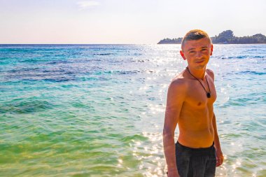 Sudaki süper mutlu adam ve Rasdhoo Mercan Maldivleri 'ndeki Rasdhoo adasındaki paradisikal tropikal bir plajda.