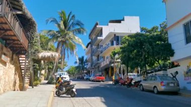 Tipik renkli turist caddesi yolu ve şehir arabalarıyla kaldırım oteller, restoranlar ve Zicatela Mexico 'daki insanlar..