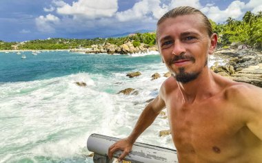Erkek turist güzel kayalıklarla selfie çekiyor kayalar kayalar kayalar, büyük sörfçü dalgaları ve Puerto Escondido Oaxaca 'da doğal manzara..