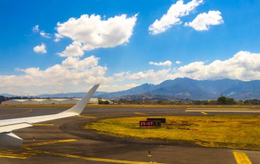 Rio Segundo Alajuela Kosta Rika 'daki uçak pisti ve şehir dağları manzaralı..
