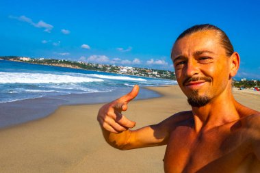Erkek turist güzel kayalıklarla selfie çekiyor kayalar kayalar kayalar, büyük sörfçü dalgaları ve Puerto Escondido Oaxaca 'da doğal manzara..