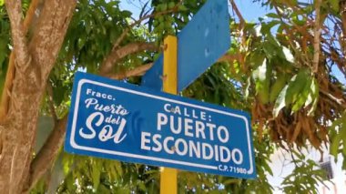 Zicatela Puerto Escondido Oaxaca Meksika 'daki cadde ve yolların oryantasyonu için mavi ve beyaz yol işaretleri ve isim.