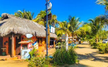 Restoran restoranlarının barları otellerde palmiye ağaçları ve Zicatela Puerto Escondido Oaxaca 'daki sahilde gezinti yerleri satıyor..