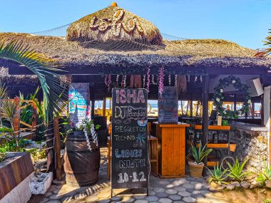Restoran restoranlarının barları otellerde palmiye ağaçları ve Zicatela Puerto Escondido Oaxaca 'daki sahilde gezinti yerleri satıyor..