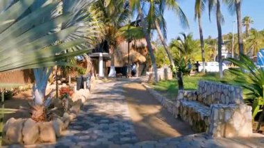 Restoran restoranlarının barları otellerde palmiye ağaçları ve Zicatela Puerto Escondido Oaxaca 'daki sahilde gezinti yerleri satıyor..