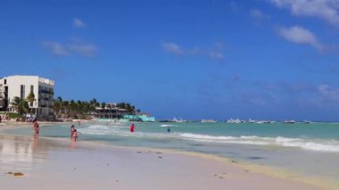 Çok eğlenceli insanlarla dolu tropik Meksika Karayip plajı ve denizi Playa del Carmen Meksika 'da güneş şemsiyesi turkuaz su..