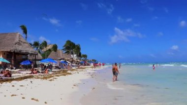 Çok eğlenceli insanlarla dolu tropik Meksika Karayip plajı ve denizi Playa del Carmen Meksika 'da güneş şemsiyesi turkuaz su..