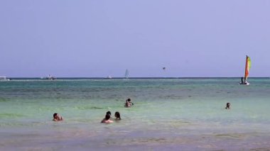 Çok eğlenceli insanlarla dolu tropik Meksika Karayip plajı ve denizi Playa del Carmen Meksika 'da güneş şemsiyesi turkuaz su..