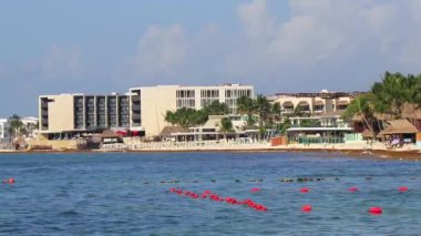 Playa del Carmen Quintana Roo Mexico 'daki Karayipler' deki büyük tatil ve otel kompleksi deniz ve palmiye ağaçları.