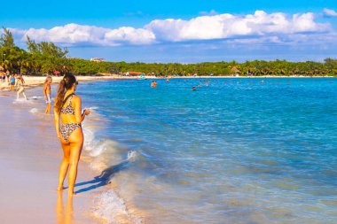 Çok eğlenceli insanlarla dolu tropik Meksika Karayip plajı ve denizi. Güneş şemsiyeleri. Playa del Carmen Meksika 'da turkuaz palmiye suyu..