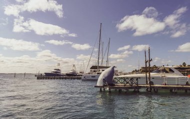 Cancun Quintana Roo Meksika 24. Mart 2022 Tekne Sürat Tekneleri Yatları ve Jetty iskelesi ve Cancun Quintana Roo Mexico 'daki Isla Mujeres adasında mavi turkuaz su ve denizde turistler.