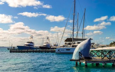 Cancun Quintana Roo Meksika 24. Mart 2022 Tekne Sürat Tekneleri Yatları ve Jetty iskelesi ve Cancun Quintana Roo Mexico 'daki Isla Mujeres adasında mavi turkuaz su ve denizde turistler.