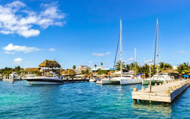 Cancun Quintana Roo Meksika 24. Mart 2022 Tekne Sürat Tekneleri Yatları ve Jetty iskelesi ve Cancun Quintana Roo Mexico 'daki Isla Mujeres adasında mavi turkuaz su ve denizde turistler.