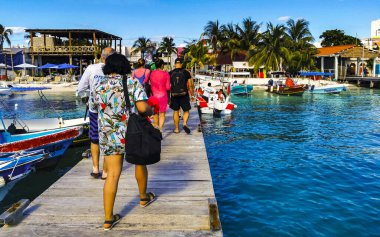 Cancun Quintana Roo Meksika 24. Mart 2022 Tekne Sürat Tekneleri Yatları ve Jetty iskelesi ve Cancun Quintana Roo Mexico 'daki Isla Mujeres adasında mavi turkuaz su ve denizde turistler.