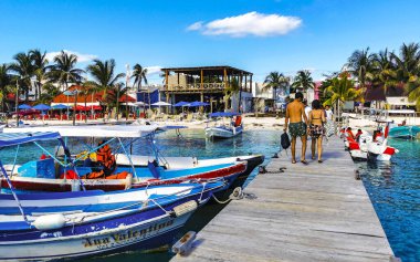 Cancun Quintana Roo Meksika 24. Mart 2022 Tekne Sürat Tekneleri Yatları ve Jetty iskelesi ve Cancun Quintana Roo Mexico 'daki Isla Mujeres adasında mavi turkuaz su ve denizde turistler.