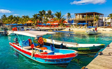 Cancun Quintana Roo Meksika 24. Mart 2022 Tekne Sürat Tekneleri Yatları ve Jetty iskelesi ve Cancun Quintana Roo Mexico 'daki Isla Mujeres adasında mavi turkuaz su ve denizde turistler.