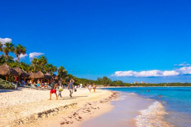 Çok eğlenceli insanlarla dolu tropik Meksika Karayip plajı ve denizi. Güneş şemsiyeleri. Playa del Carmen Meksika 'da turkuaz palmiye suyu..