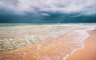 Playa del Carmen Meksika 'da berrak turkuvaz mavi su dalgaları ve kara bulutlarla şaşırtıcı tropikal Meksika Karayip plajı ve deniz manzarası manzarası..