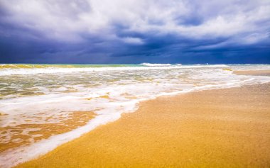 Playa del Carmen Meksika 'da berrak turkuvaz mavi su dalgaları ve kara bulutlarla şaşırtıcı tropikal Meksika Karayip plajı ve deniz manzarası manzarası..