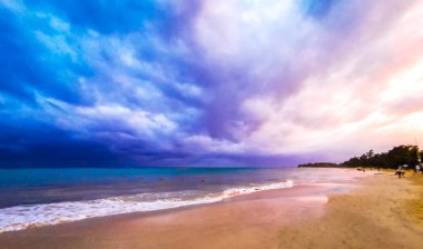 Amazing colorful sunset sunrise at tropical mexican caribbean beach landscape panorama with clear turquoise blue water clouds sunshine and beautiful colors. clipart