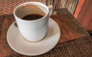 Playa del Carmen Quintana Roo Meksika 'daki restoran kafeteryasında bir tabak kaşık ve tabakla bir bardak koyu americano kahvesi..