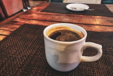 Playa del Carmen Quintana Roo Meksika 'daki restoran kafeteryasında bir tabak kaşık ve tabakla bir bardak koyu americano kahvesi..