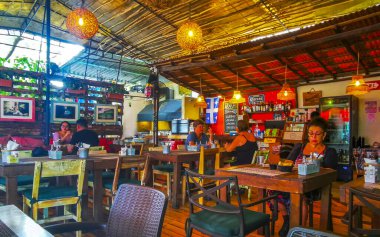 Playa del Carmen Quintana Roo Mexico 'da masa sandalyeleri dekorasyon masası ve bitkilerle dolu bir restoran barının içinde..