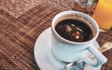 Playa del Carmen Quintana Roo Meksika 'daki restoran kafeteryasında bir tabak kaşık ve tabakla bir bardak koyu americano kahvesi..