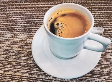 Playa del Carmen Quintana Roo Meksika 'daki restoran kafeteryasında bir tabak kaşık ve tabakla bir bardak koyu americano kahvesi..