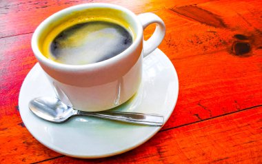 Playa del Carmen Quintana Roo Meksika 'daki restoran kafeteryasında bir tabak kaşık ve tabakla bir bardak koyu americano kahvesi..