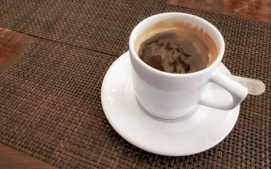 Playa del Carmen Quintana Roo Meksika 'daki restoran kafeteryasında bir tabak kaşık ve tabakla bir bardak koyu americano kahvesi..