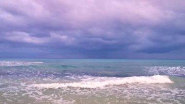 Playa del Carmen Meksika 'da berrak turkuvaz mavi su dalgaları ve kara bulutlarla şaşırtıcı tropikal Meksika Karayip plajı ve deniz manzarası manzarası..