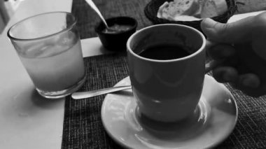 Playa del Carmen Quintana Roo Meksiko 'daki restoran kafeteryasında bir fincan siyah americano kahvesi ve bir tabak yemek ve içecek..