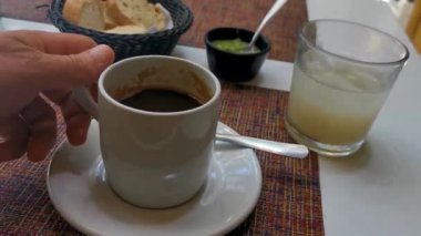 Playa del Carmen Quintana Roo Meksiko 'daki restoran kafeteryasında bir fincan siyah americano kahvesi ve bir tabak yemek ve içecek..