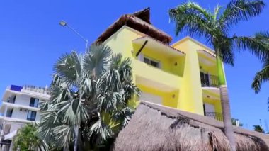 Playa del Carmen Quintana Roo Meksika 'da tropik cennette, palmiye ağaçları ve turuncu renkli modern tipik binalar ve mimari oteller tatil beldeleri ve daireler..