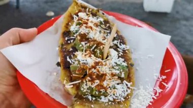 Mexican food tlakobananas tlakojos of banana dough with cheese beans spinach and hot sauce in Playa del Carmen Quintana Roo Mexico.