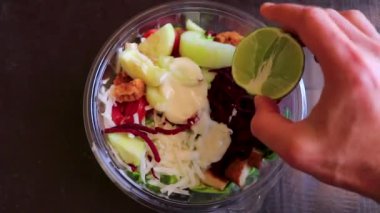 Sağlıklı yeşil salata kasesinin üzerine limon sıkın. Meksika yemeği. Playa del Carmen Quintana Roo Mexico 'daki restoran..