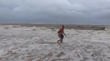 Adam kasırga sırasında plajda ve Playa del Carmen Quintana Roo Mexico 'da eğleniyor..