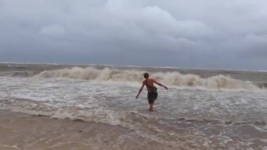 Adam kasırga sırasında plajda ve Playa del Carmen Quintana Roo Mexico 'da eğleniyor..